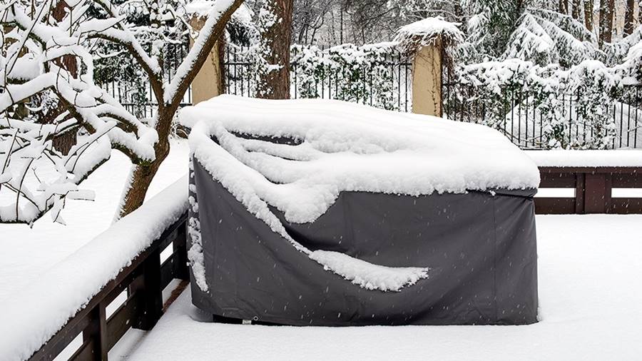 A covered piece of patio furniture stands as a silent testament to thoughtful seasonal preparation