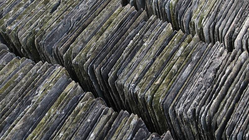 Stacks of reclaimed slate tiles showcasing the sustainable practice of recycling building materials for environmental benefits