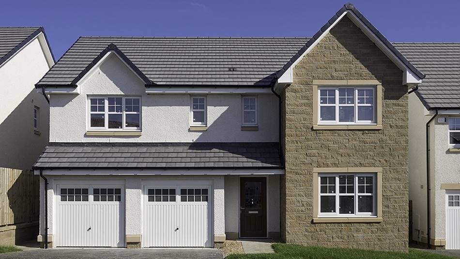 New build house with stone facade and white garage doors