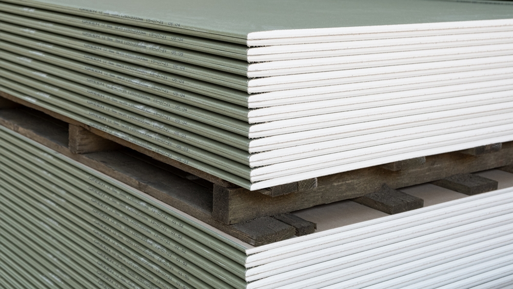 Stack of moisture-resistant drywall plasterboards ready for installation