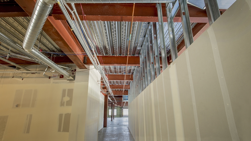 Interior of an office building under construction with drywall plasterboard installed on a metal frame system.