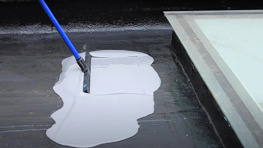 Application of liquid-applied membrane on a flat roof using a squeegee