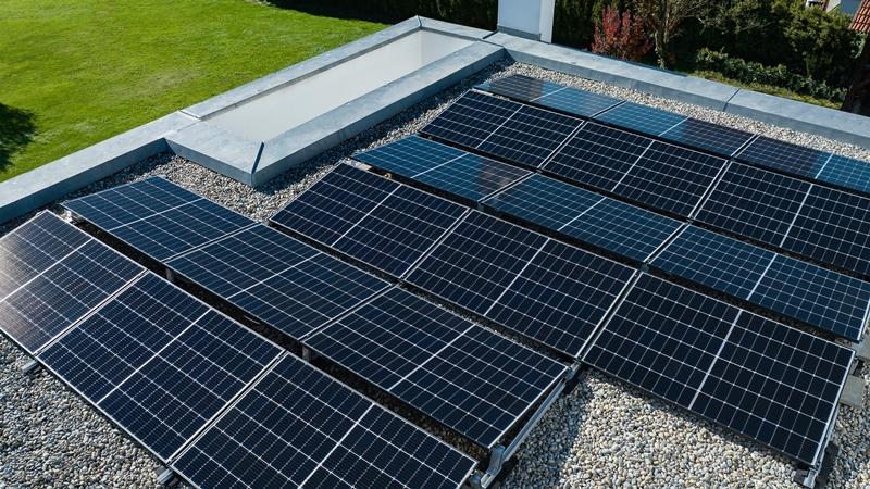 Solar panels installed on a built-up roof with a gravel surface for renewable energy generation.