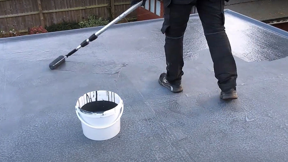 Applying a topcoat to a GRP roof with a roller for a smooth and durable finish