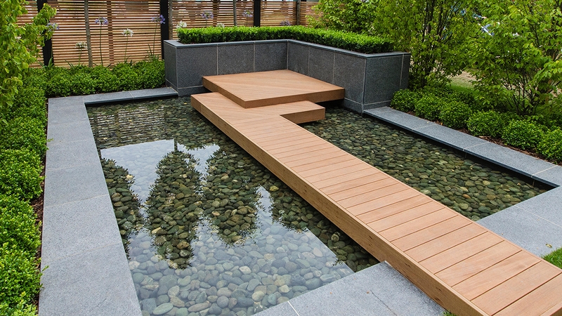 Contemporary formal pond with a wooden walkway