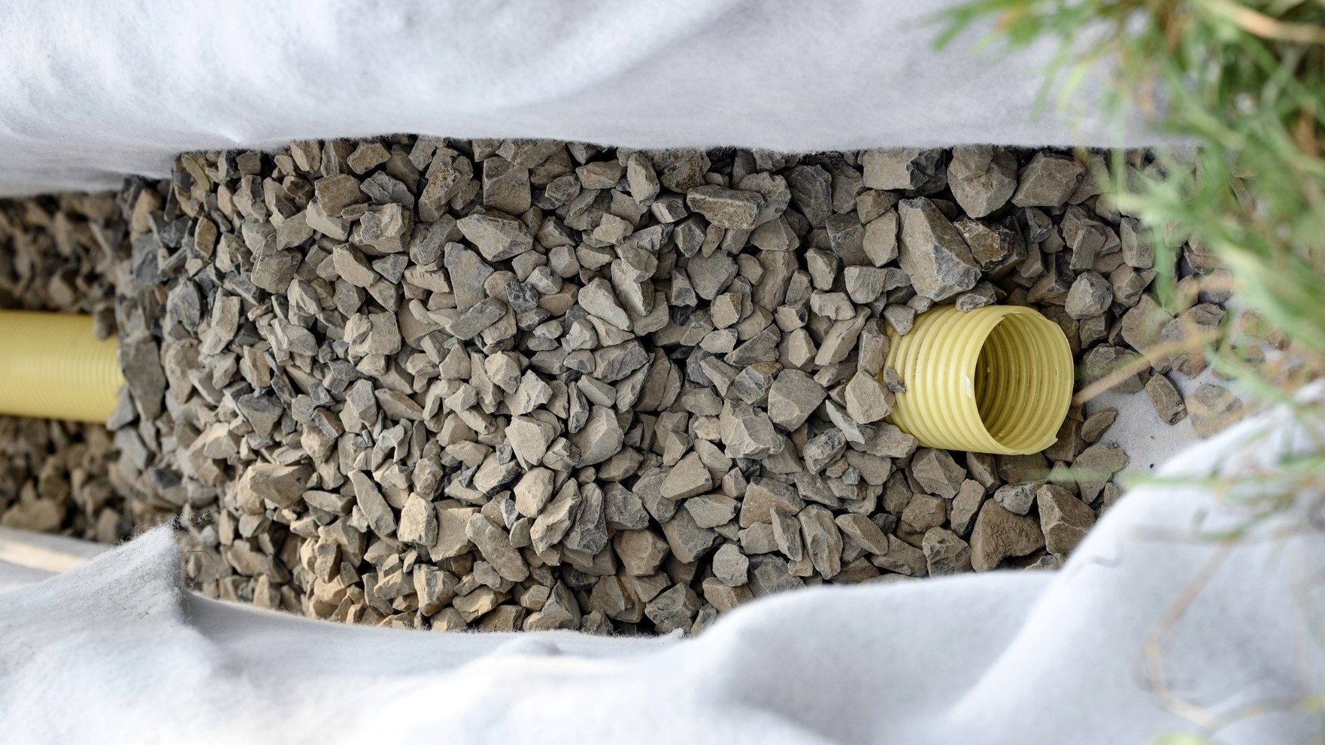 Perforated yellow land drain within clean stone and geotextile fabric